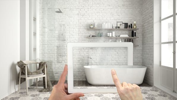 A bathroom scene, with an overlay of a person holding a tablet, dragging a 3D model of a bathtub into the room