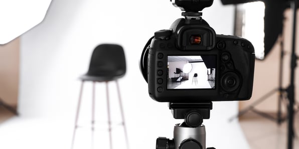 A chair in a photography studio is in the background, with a camera visualizer showing the scene in the foreground